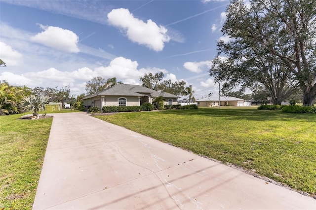 view of front of property with concrete driveway and a front yard