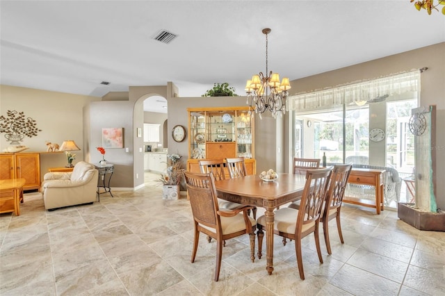 dining space featuring baseboards, visible vents, arched walkways, and a chandelier