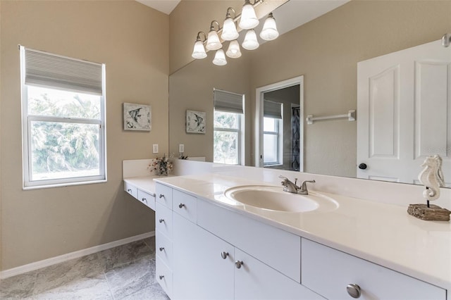 full bath featuring vanity and baseboards