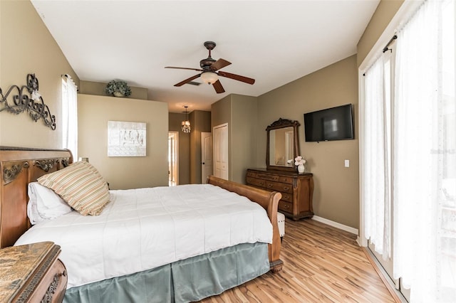 bedroom with ceiling fan, light wood-style flooring, and baseboards