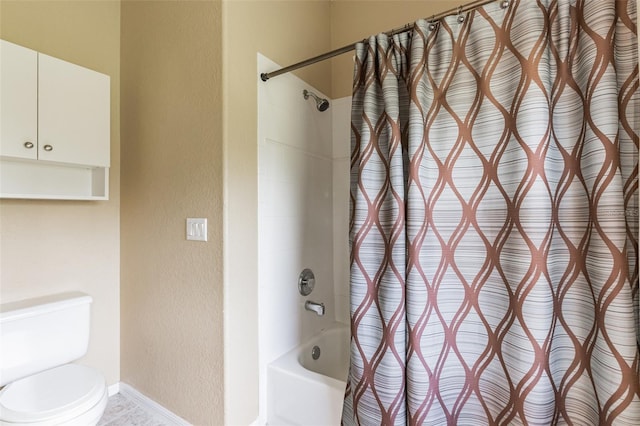 bathroom featuring toilet, baseboards, shower / bath combo with shower curtain, and a textured wall