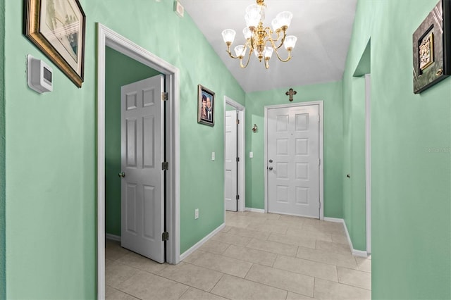 entrance foyer with light tile patterned floors, baseboards, and a notable chandelier