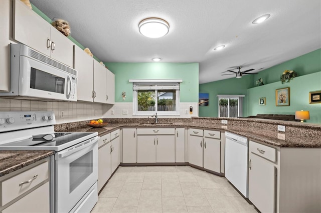kitchen with white appliances, tasteful backsplash, ceiling fan, a peninsula, and a sink