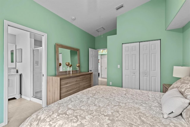 bedroom featuring attic access, visible vents, connected bathroom, lofted ceiling, and a closet