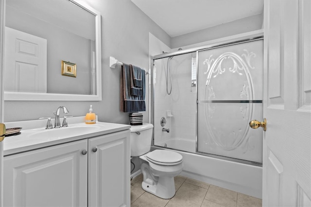 bathroom with tile patterned flooring, shower / bath combination with glass door, vanity, and toilet