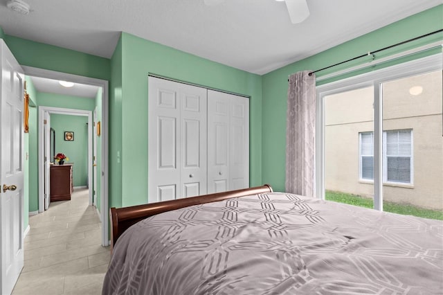 bedroom featuring a closet, light tile patterned flooring, and a ceiling fan