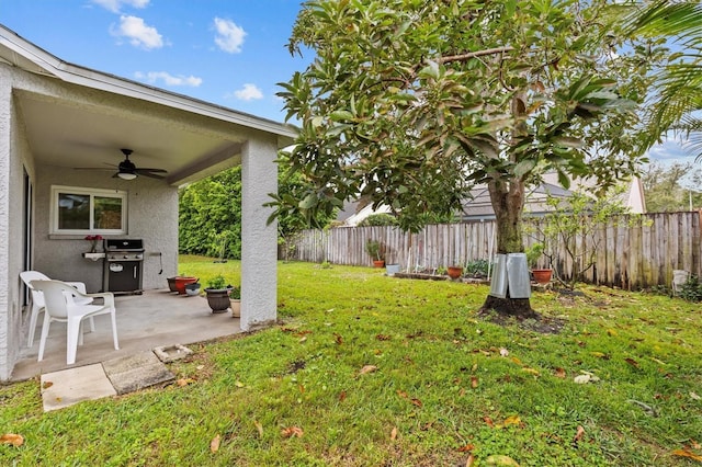 view of yard with a patio, fence, and a ceiling fan