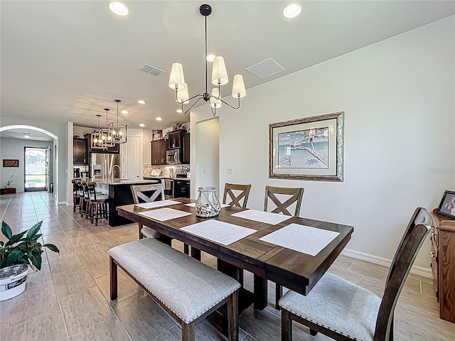 dining space with recessed lighting, visible vents, arched walkways, and a chandelier