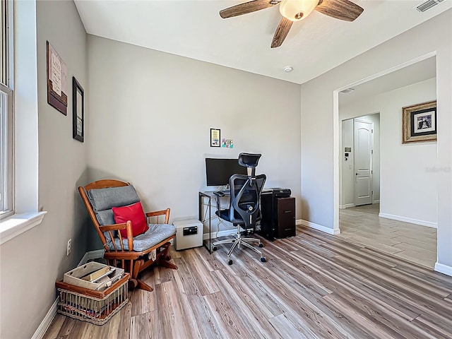 office space featuring visible vents, a ceiling fan, baseboards, and wood finished floors