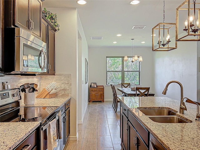 kitchen featuring visible vents, appliances with stainless steel finishes, decorative backsplash, and a sink