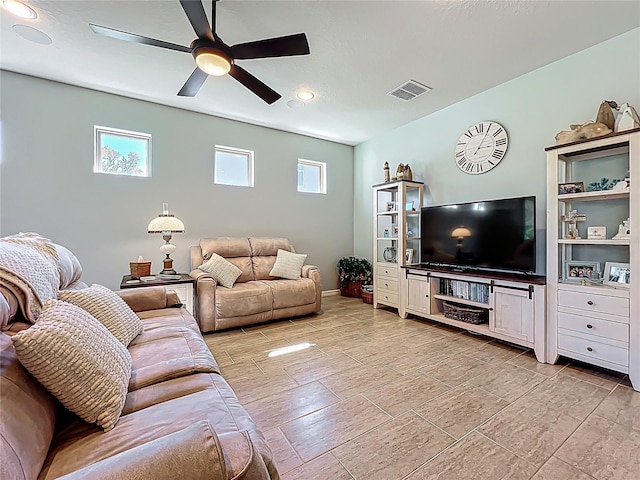 living area with a ceiling fan, visible vents, and baseboards