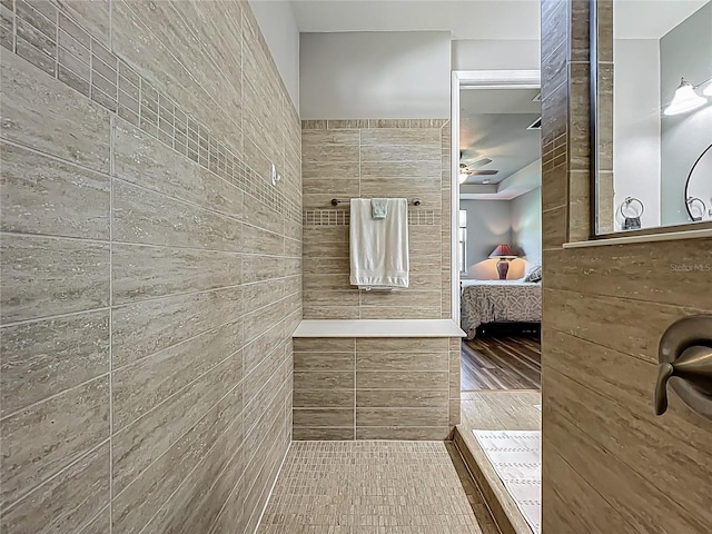 ensuite bathroom featuring a tile shower, ensuite bath, and ceiling fan