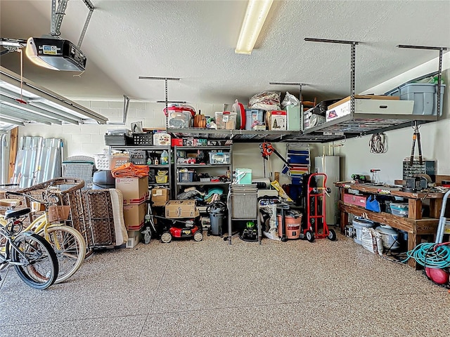 garage with concrete block wall and a garage door opener