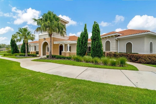 mediterranean / spanish-style home with stucco siding, a tiled roof, a pergola, and a front yard