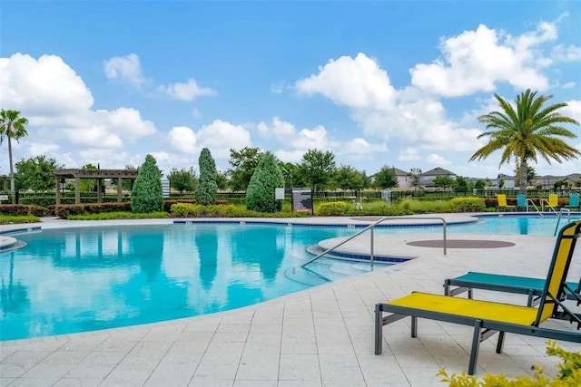 pool featuring fence and a patio area