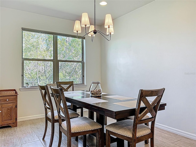 dining space with recessed lighting, light wood-type flooring, baseboards, and a notable chandelier