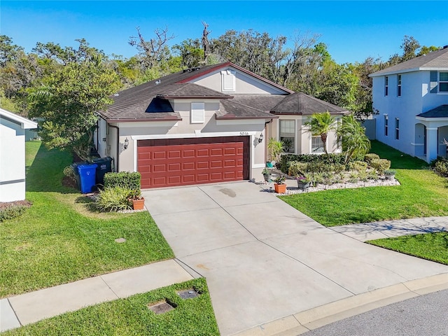 view of front of home with stucco siding, an attached garage, concrete driveway, and a front yard