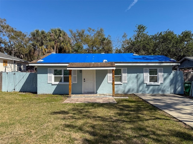 ranch-style home with a front yard, fence, and stucco siding