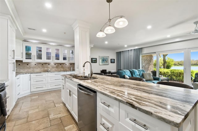 kitchen with dishwasher, backsplash, stone tile flooring, a sink, and recessed lighting