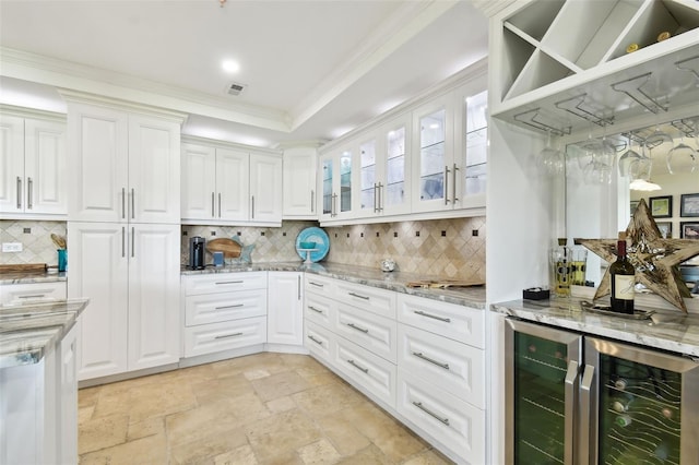 kitchen featuring visible vents, glass insert cabinets, white cabinets, light stone countertops, and beverage cooler