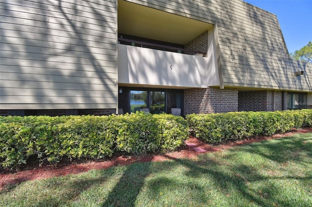 exterior space with a lawn and brick siding