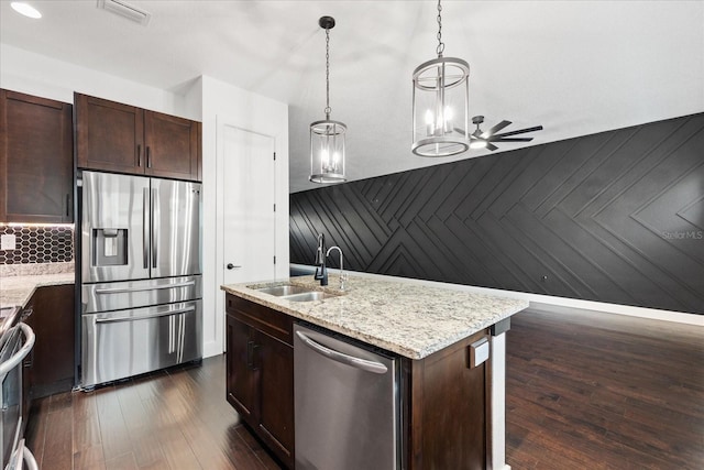 kitchen featuring visible vents, a sink, dark wood finished floors, appliances with stainless steel finishes, and a kitchen island with sink