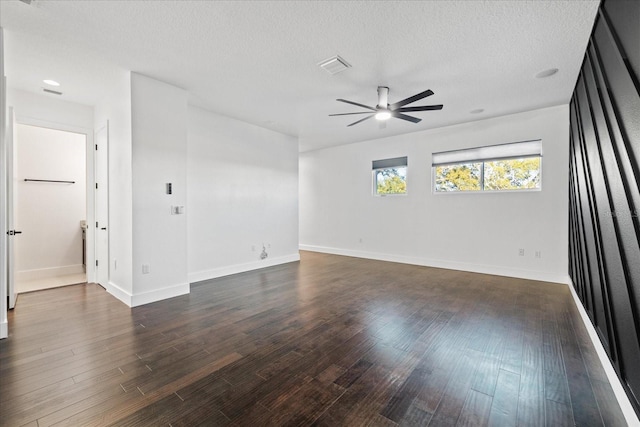 unfurnished room featuring baseboards, dark wood-style floors, visible vents, and ceiling fan