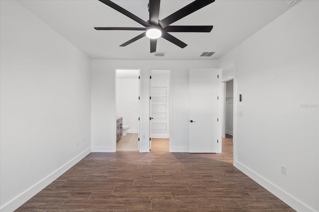 unfurnished bedroom with visible vents, baseboards, ensuite bathroom, a ceiling fan, and dark wood-style flooring