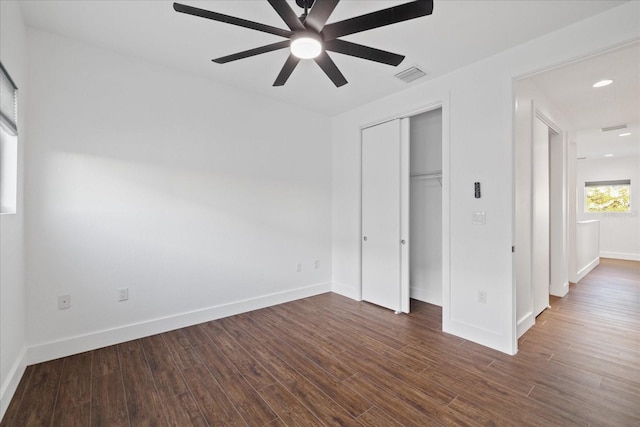 unfurnished bedroom with dark wood-style floors, visible vents, baseboards, recessed lighting, and a closet