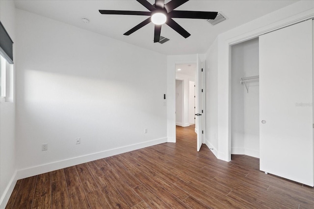 unfurnished bedroom featuring wood finished floors, visible vents, baseboards, ceiling fan, and a closet