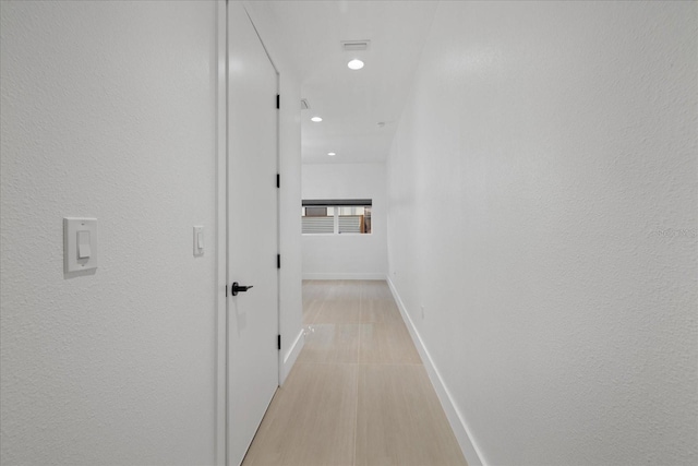 hall featuring recessed lighting and baseboards