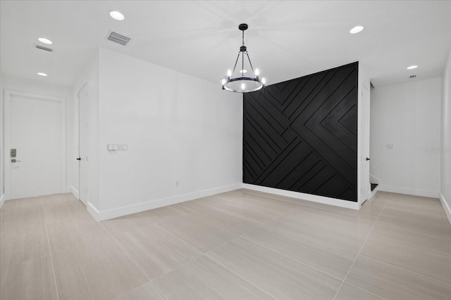 interior space featuring visible vents, a notable chandelier, recessed lighting, baseboards, and an accent wall