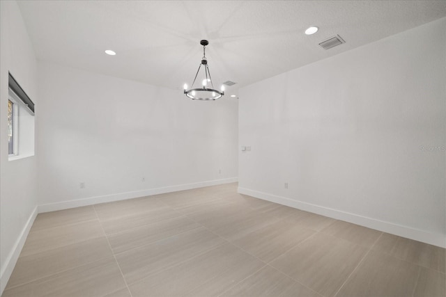 spare room featuring recessed lighting, a notable chandelier, baseboards, and visible vents