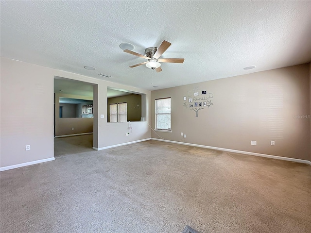 unfurnished room featuring visible vents, baseboards, light colored carpet, and ceiling fan