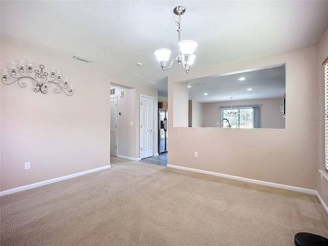 unfurnished room featuring a chandelier, visible vents, baseboards, and carpet floors