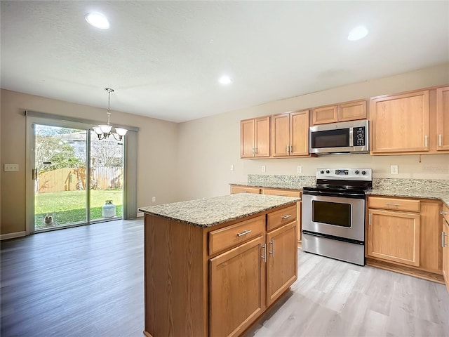 kitchen featuring light brown cabinets, stainless steel appliances, light wood-style floors, and light stone countertops