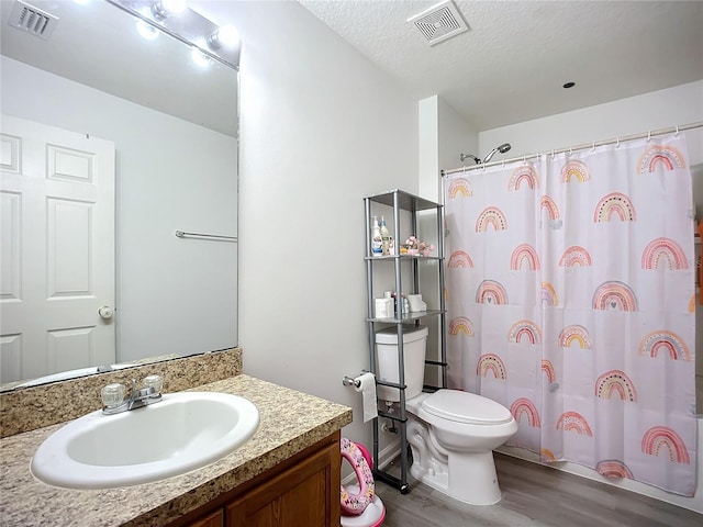 full bathroom with visible vents, toilet, wood finished floors, and a textured ceiling