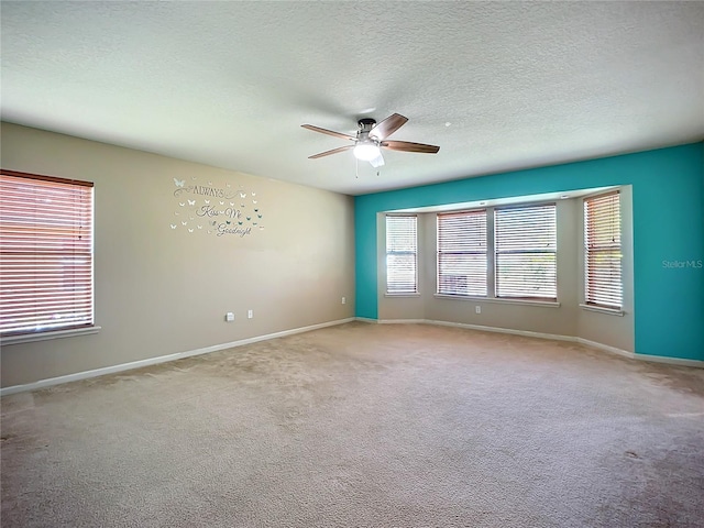 unfurnished room with a textured ceiling, ceiling fan, and carpet