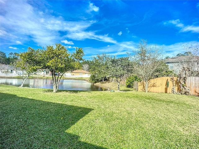 view of yard with fence and a water view