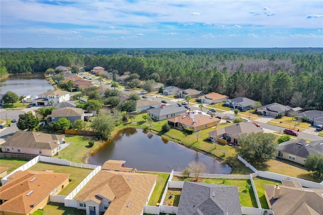 birds eye view of property featuring a forest view, a water view, and a residential view