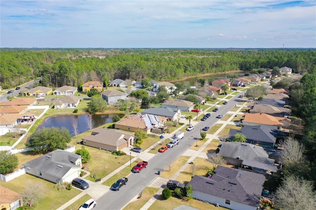 bird's eye view with a residential view, a view of trees, and a water view