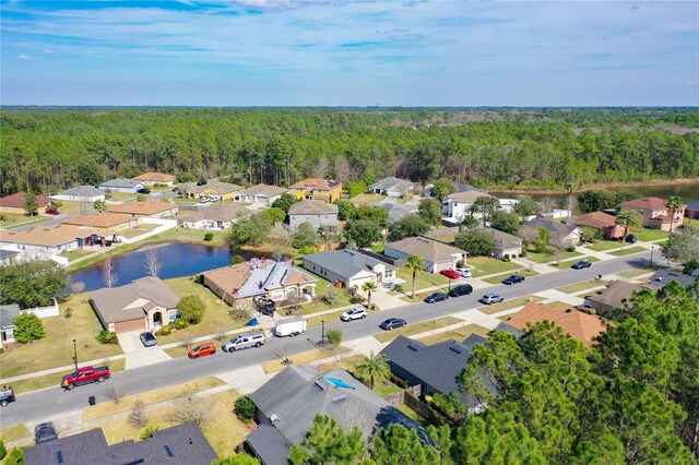 birds eye view of property featuring a residential view, a wooded view, and a water view