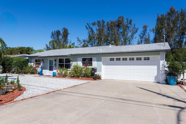 ranch-style home with concrete driveway and an attached garage