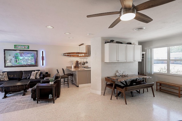 living room featuring light speckled floor, ceiling fan, recessed lighting, visible vents, and baseboards