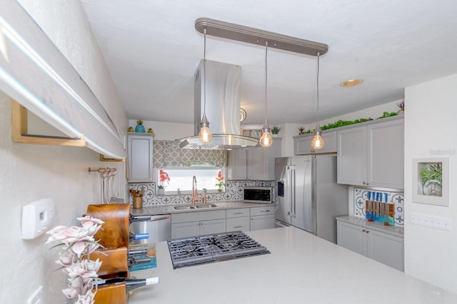 kitchen with backsplash, appliances with stainless steel finishes, light countertops, and a sink