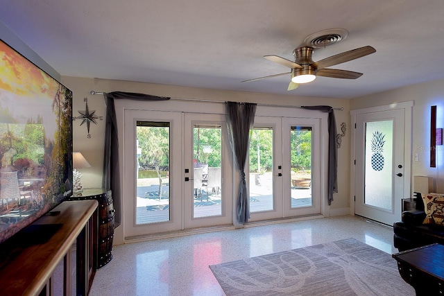 doorway to outside featuring visible vents, light speckled floor, a ceiling fan, and french doors