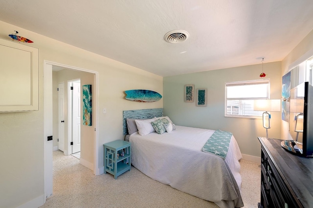 bedroom with light speckled floor, visible vents, and baseboards