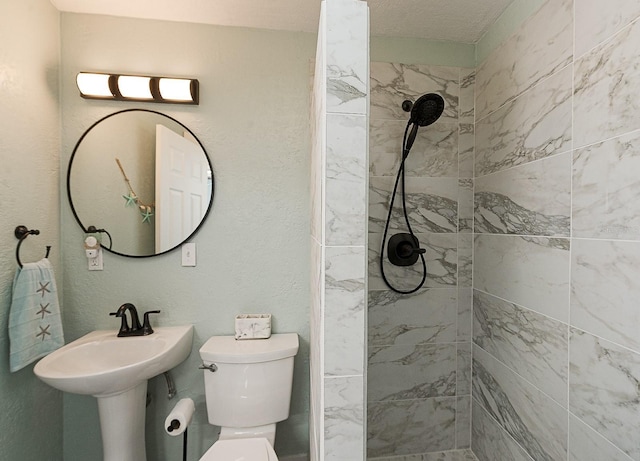 bathroom with toilet and a tile shower