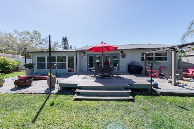 rear view of house with a fire pit, a yard, and a wooden deck