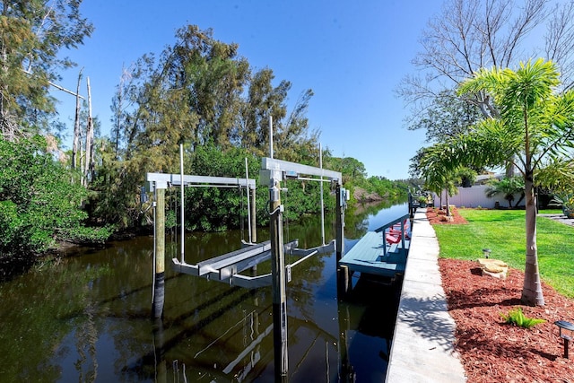 view of dock featuring a lawn, a water view, and boat lift